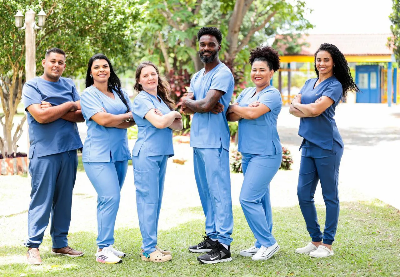 Equipe de saúde uniformizada com scrubs azuis do Ateliê da Linia